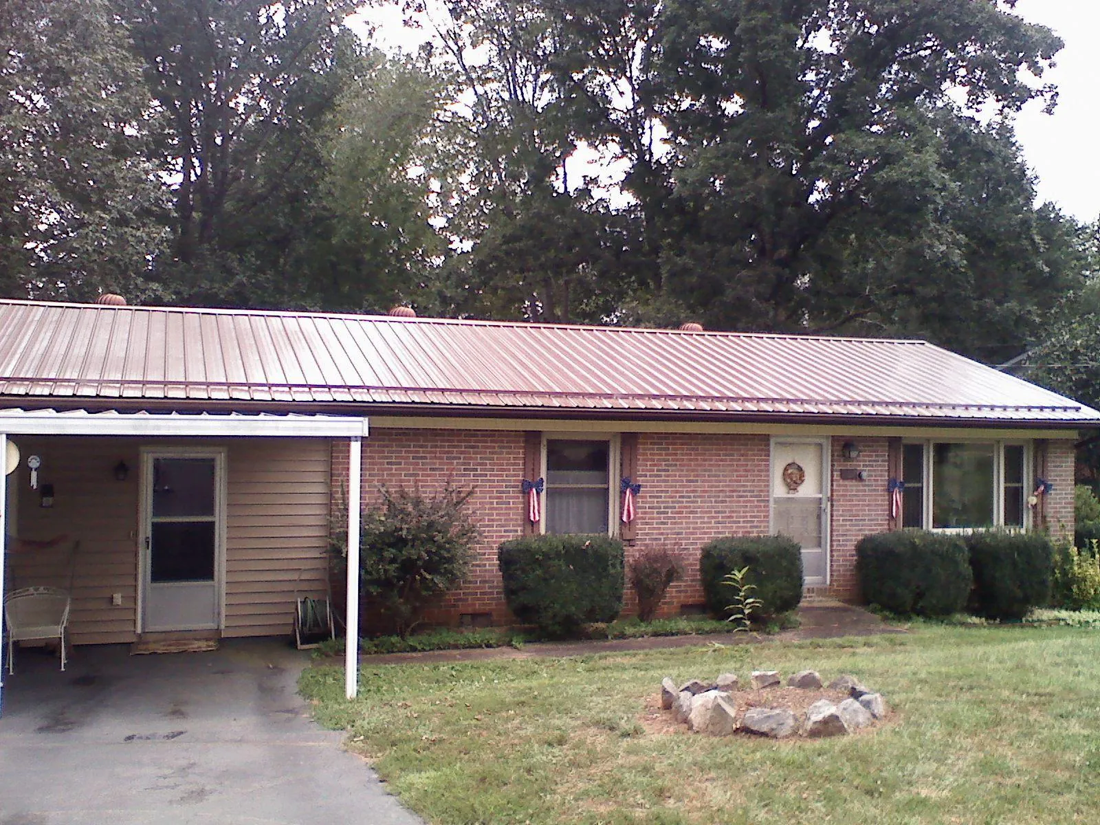 Bronze metal roof and carport on a brick ranch home — Roof Repair work by our crew in Friendship